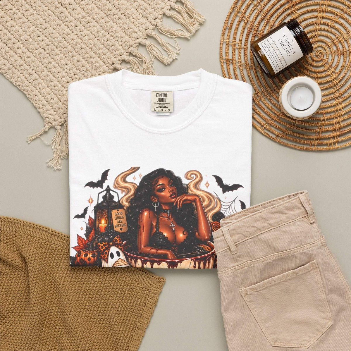 Unisex Garment-Dyed T-shirt in white with detailed Halloween graphic featuring a stylish woman, skull coffee mug, pumpkins, ghosts, bats, and candles
