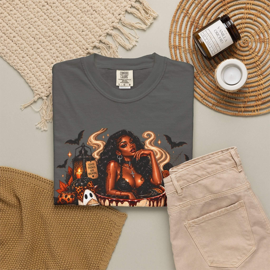 Unisex Garment-Dyed T-shirt in charcoal grey featuring a bold Halloween graphic with a stylish woman, skull, pumpkins, ghosts, and bats